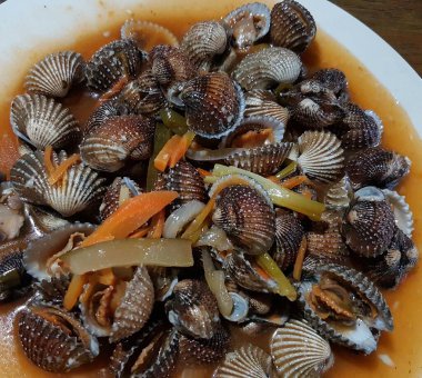 Tatlı ve ekşi deniz tarakları, işlenmiş taze kabuklu deniz ürünleri, acı biber sosu, domates, zencefil, bombay, sarımsak ve istiridye sosuyla pişirilmiş bir yemektir.