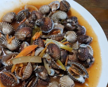 Tatlı ve ekşi deniz tarakları, işlenmiş taze kabuklu deniz ürünleri, acı biber sosu, domates, zencefil, bombay, sarımsak ve istiridye sosuyla pişirilmiş bir yemektir.