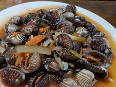 Tatlı ve ekşi deniz tarakları, işlenmiş taze kabuklu deniz ürünleri, acı biber sosu, domates, zencefil, bombay, sarımsak ve istiridye sosuyla pişirilmiş bir yemektir.