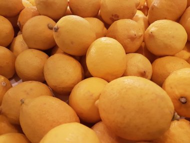 Limon, portakal, arka plan olarak taze meyve karışımı, üst manzara. Taze narenciye pazarı. Üstünde bir yığın portakal oturuyor.