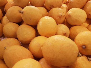 Limon, portakal, arka plan olarak taze meyve karışımı, üst manzara. Taze narenciye pazarı. Üstünde bir yığın portakal oturuyor.