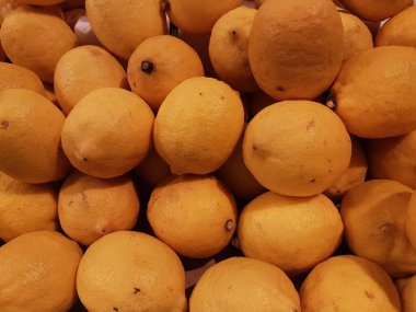 Limon, portakal, arka plan olarak taze meyve karışımı, üst manzara. Taze narenciye pazarı. Üstünde bir yığın portakal oturuyor.