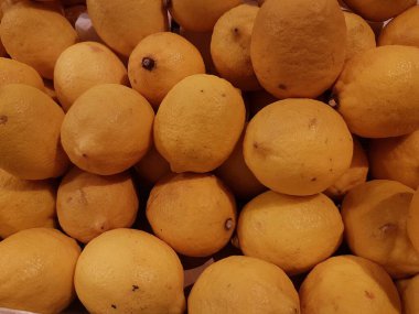 Limon, portakal, arka plan olarak taze meyve karışımı, üst manzara. Taze narenciye pazarı. Üstünde bir yığın portakal oturuyor.