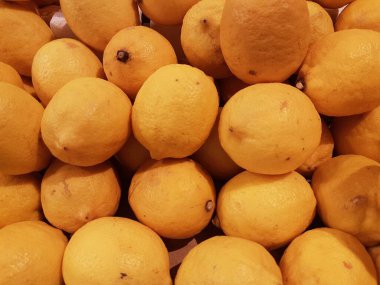 Limon, portakal, arka plan olarak taze meyve karışımı, üst manzara. Taze narenciye pazarı. Üstünde bir yığın portakal oturuyor.