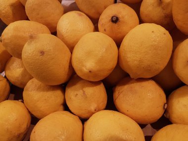 Limon, portakal, arka plan olarak taze meyve karışımı, üst manzara. Taze narenciye pazarı. Üstünde bir yığın portakal oturuyor.