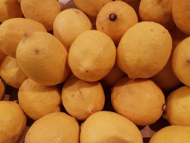 Limon, portakal, arka plan olarak taze meyve karışımı, üst manzara. Taze narenciye pazarı. Üstünde bir yığın portakal oturuyor.