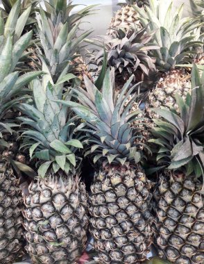 Markette taze ananas var. Organik çiftliklerden gelen egzotik meyveler. Alıcıları çekmek için pazarda meyve ticareti.