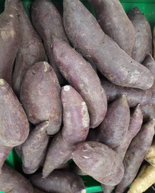 Pazar için tatlı patatesler. Tezgahta taze patates var. Arkaplan ya da doku olarak kullanılabilen tatlı patates yığını resmi