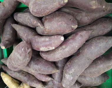 Pazar için tatlı patatesler. Tezgahta taze patates var. Arkaplan ya da doku olarak kullanılabilen tatlı patates yığını resmi