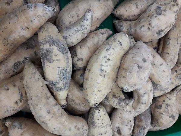 Pazar için tatlı patatesler. Tezgahta taze patates var. Arkaplan ya da doku olarak kullanılabilen tatlı patates yığını resmi