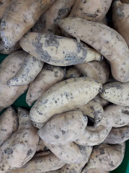 Pazar için tatlı patatesler. Tezgahta taze patates var. Arkaplan ya da doku olarak kullanılabilen tatlı patates yığını resmi