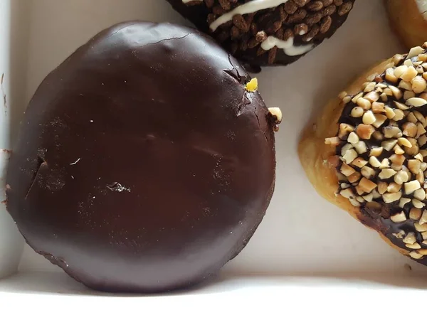 Colorful donuts in a box. Sweet icing sugar food with glazed sprinkles, doughnut with chocolate frosting. Top view with copy space