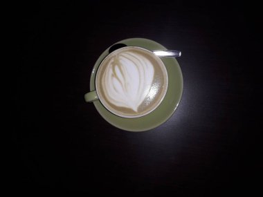 Kahveli sütlü kahve. Aroma kahve fincanı ve kahve çekirdekleri ahşap masada..