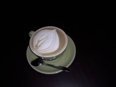 Kahveli sütlü kahve. Aroma kahve fincanı ve kahve çekirdekleri ahşap masada..