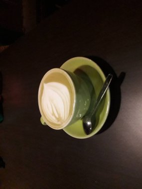 Kahveli sütlü kahve. Aroma kahve fincanı ve kahve çekirdekleri ahşap masada..