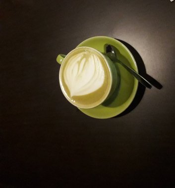 Kahveli sütlü kahve. Aroma kahve fincanı ve kahve çekirdekleri ahşap masada..