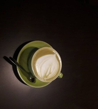 Kahveli sütlü kahve. Aroma kahve fincanı ve kahve çekirdekleri ahşap masada..