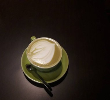 Kahveli sütlü kahve. Aroma kahve fincanı ve kahve çekirdekleri ahşap masada..