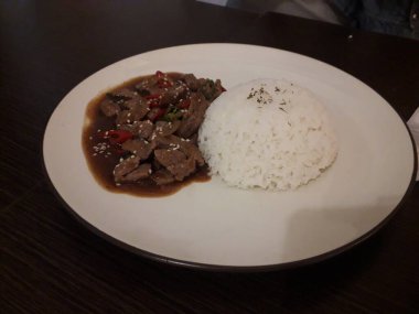 Beyaz pilav (Tayland yasemin pilavı), beyaz tabakta pilav ve ahşap bambu arkaplanda çubuklar..