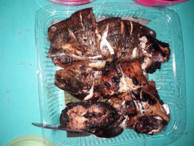 Lezzetli büyük Nil tilapia balığının yeşil zemin üzerinde basit yeşil tabak ve metin için kopya alanı ile üst görünümü