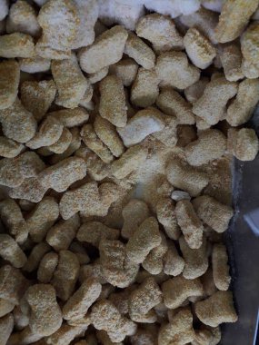 Frozen breaded orange chicken nugget sticks texture in the market fridge as a background. Close up photography