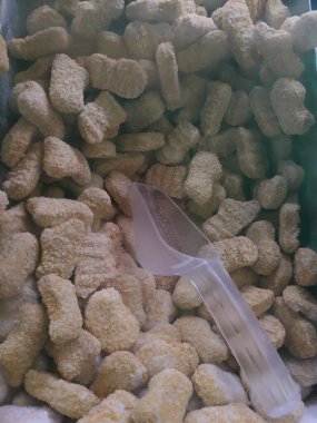 Frozen breaded orange chicken nugget sticks texture in the market fridge as a background. Close up photography