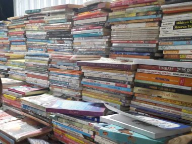 Kütüphanedeki masada yığınla kitap