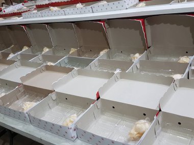 Stack of pizza boxes. Cardboard brown boxes for shipping and delivery of pizza. Many packaging is on the kitchen stock. Food order and delivering concept. Front view.