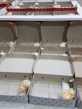 Stack of pizza boxes. Cardboard brown boxes for shipping and delivery of pizza. Many packaging is on the kitchen stock. Food order and delivering concept. Front view.