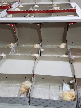 Stack of pizza boxes. Cardboard brown boxes for shipping and delivery of pizza. Many packaging is on the kitchen stock. Food order and delivering concept. Front view.