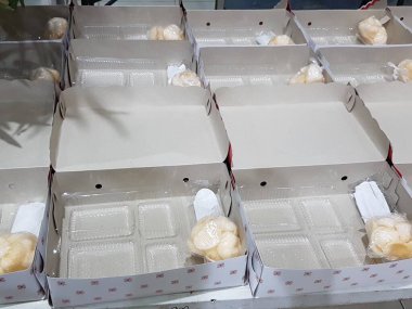 Stack of pizza boxes. Cardboard brown boxes for shipping and delivery of pizza. Many packaging is on the kitchen stock. Food order and delivering concept. Front view.