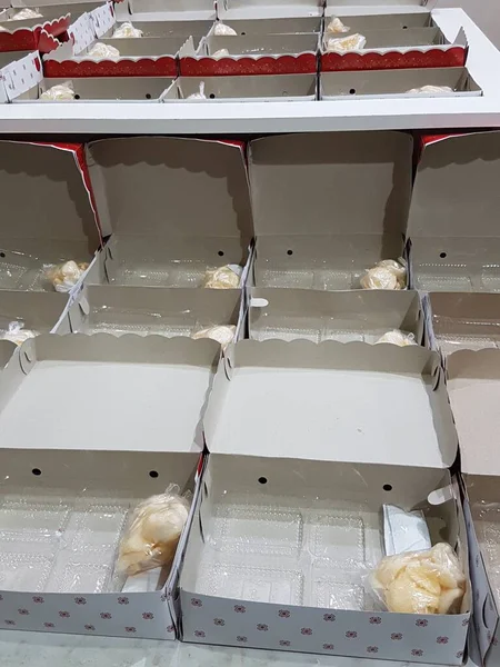 Stack of pizza boxes. Cardboard brown boxes for shipping and delivery of pizza. Many packaging is on the kitchen stock. Food order and delivering concept. Front view.