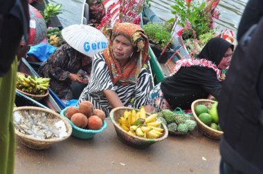 Banjarmasin, South Kalimantan, Indonesia - August 15, 2022 : Women from Lok Baintan joining the Jukung Bungas festival in Banjarmasin. Floating market in Borneo, kalimantan where dealer sell fruit and vegetables
