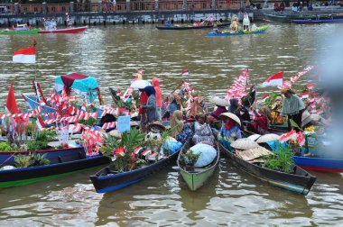 Banjarmasin, South Kalimantan, Indonesia - August 15, 2022 : Women from Lok Baintan joining the Jukung Bungas festival in Banjarmasin. Floating market in Borneo, kalimantan where dealer sell fruit and vegetables