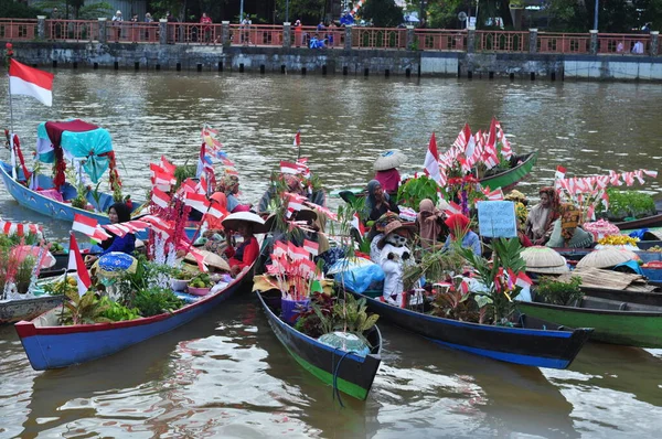 Banjarmasin, South Kalimantan, Indonesia - August 15, 2022 : Women from Lok Baintan joining the Jukung Bungas festival in Banjarmasin. Floating market in Borneo, kalimantan where dealer sell fruit and vegetables