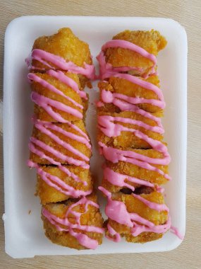 Vegan dessert, Selective focus Banana Grill with strawberry and cheesee garnish called pisang bakar keju. Served on white plate.
