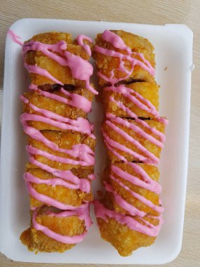 Vegan dessert, Selective focus Banana Grill with strawberry and cheesee garnish called pisang bakar keju. Served on white plate.