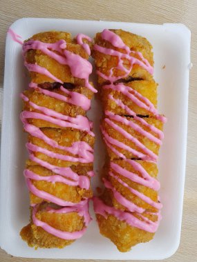Vegan dessert, Selective focus Banana Grill with strawberry and cheesee garnish called pisang bakar keju. Served on white plate.