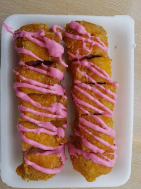 Vegan dessert, Selective focus Banana Grill with strawberry and cheesee garnish called pisang bakar keju. Served on white plate.