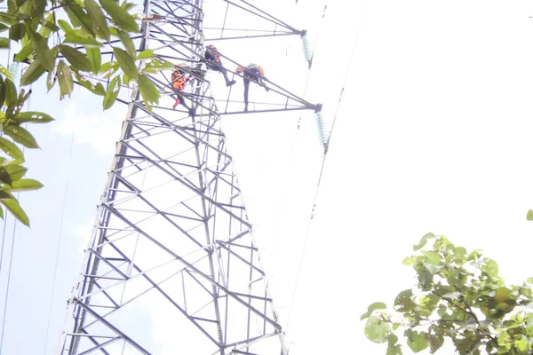 印度尼西亚南加里曼丹Banjarmasin 2022年8月10日 电工在模糊的自然背景下 安全和系统地在高压电站安装高压 — 图库照片