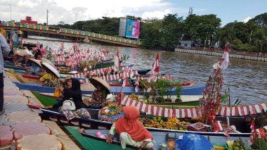 Banjarmasin, Endonezya, 10 Aralık 2021: Barito Nehri 'nde ve Banjarmasin' de Lok Baintan, Kalimantan (Endonezya Borneo) kanallarında geleneksel yüzen pazar ürünleri satışı. Özellikle kadınlar tarafından işletilen eşsiz bir geleneksel pazar.