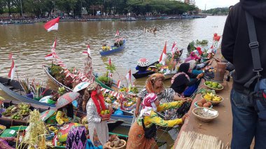 Banjarmasin, Endonezya, 10 Aralık 2021: Barito Nehri 'nde ve Banjarmasin' de Lok Baintan, Kalimantan (Endonezya Borneo) kanallarında geleneksel yüzen pazar ürünleri satışı. Özellikle kadınlar tarafından işletilen eşsiz bir geleneksel pazar.