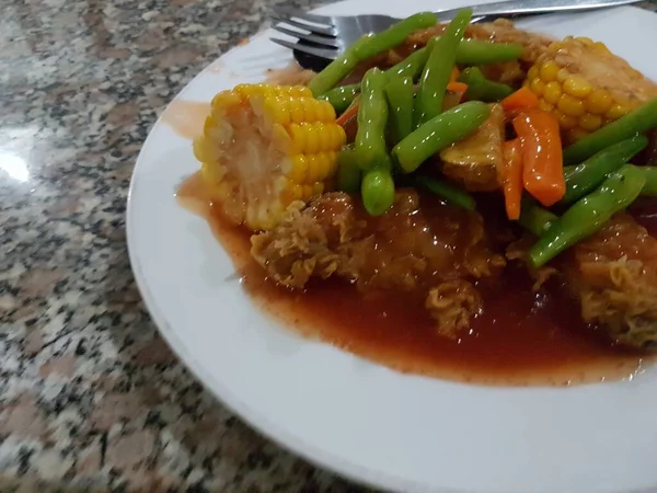 インドネシア料理 Ayam Goreng Saus Asam Manis 鶏の唐揚げに甘酸っぱいソース 白を基調としたホワイトプレートに盛り付け 選択的焦点 — ストック写真