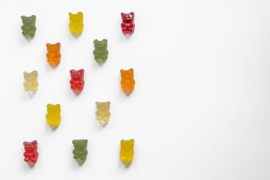 gummy bears laid out in rows in a checkerboard pattern on a light background, top view