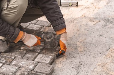 Asfalt döşeme levhaları yakın plan. Yol yüzeyi, inşaat. Kaldırım tamiri. Taş döşeyen işçiler. Şehir parkının bahçesine fayanslar seriyorum. .