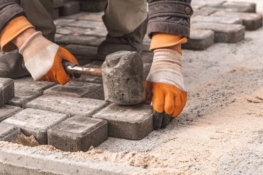 Asfalt döşeme levhaları yakın plan. Yol yüzeyi, inşaat. Kaldırım tamiri. Taş döşeyen işçiler. Şehir parkının bahçesine fayanslar seriyorum. .