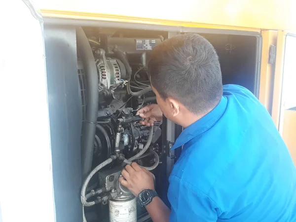 Surabaya / Endonezya - 2 Eylül 2019: Tamirci bozuk bir makineyi tamir etmeye çalışıyor