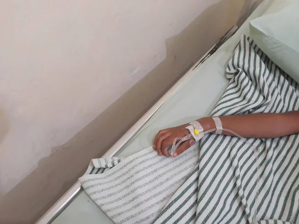 Çocuğun eli, yatağın üstündeki hastane odasında birleşiyor.