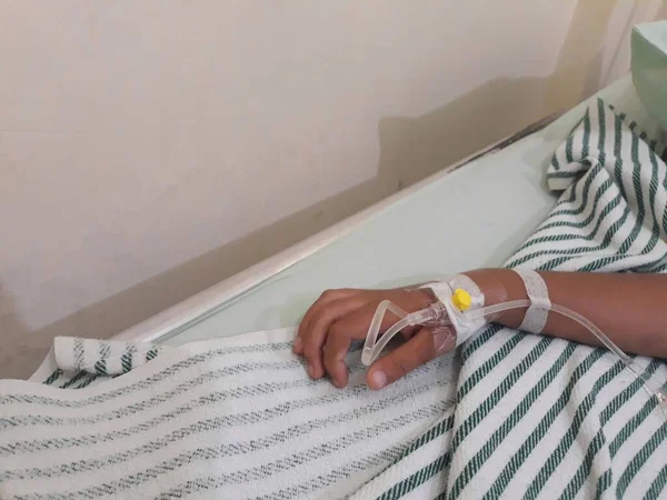 Çocuğun eli, yatağın üstündeki hastane odasında birleşiyor.