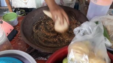 Cingur salatası havan topuzuyla baharatları karıştırıyor. Sokak yemekleri standı